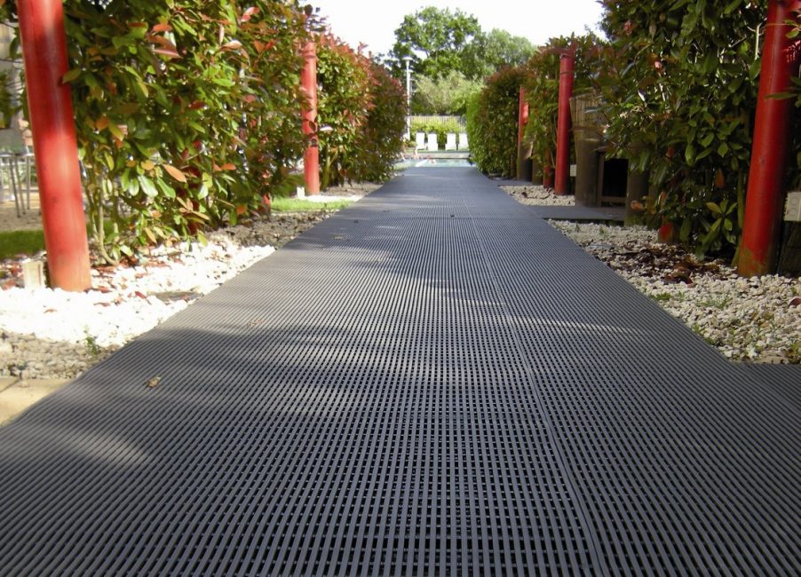 Des dalles en plastique noir à haute résistance sont utilisées pour construire la route principale menant à la maison.