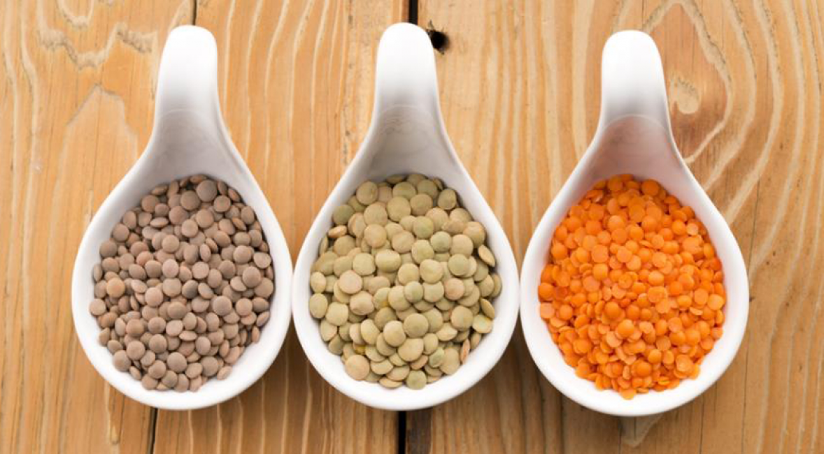 Grains de lentilles de différentes variétés, parmi lesquelles il y a aussi un représentant rouge des légumineuses.