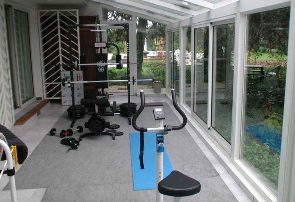 S'il n'y a pas assez d'espace dans la maison pour l'équipement de la salle de gym, utilisez la véranda à cet effet.
