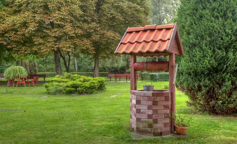 Puits décoratif à la campagne avec une tête en brique