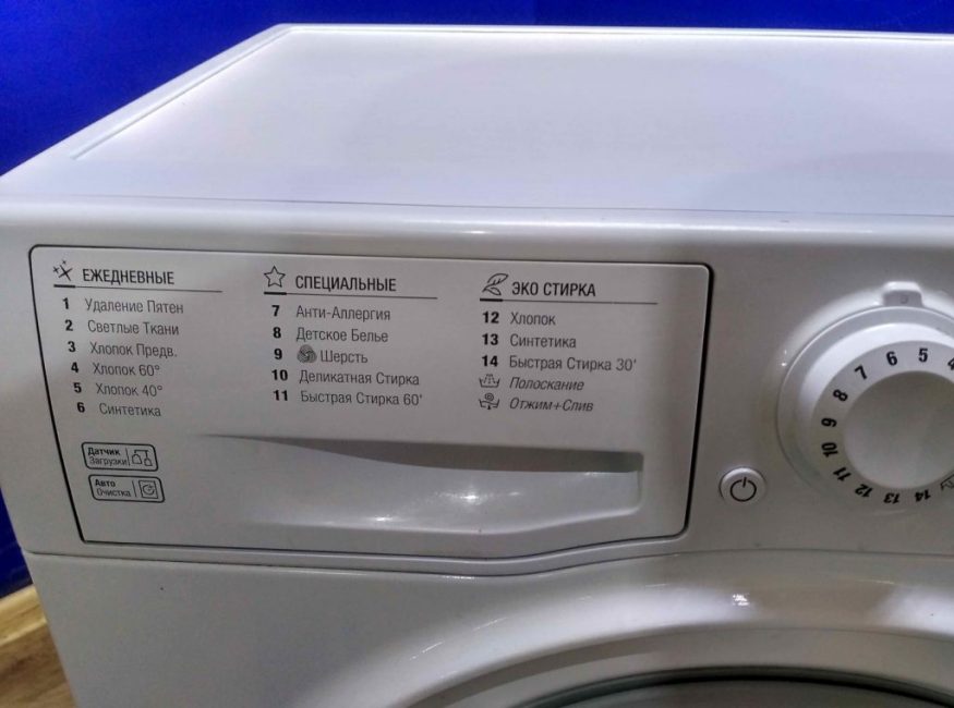 Sur le côté du panneau avant se trouvent les codes numériques des opérations effectuées par la machine. L'utilisateur sélectionne le mode de fonctionnement en tournant le bouton central avec des chiffres. Pour déterminer les conditions de lavage, le levier avec le numéro correspondant s'arrête devant l'icône située au-dessus du bouton
