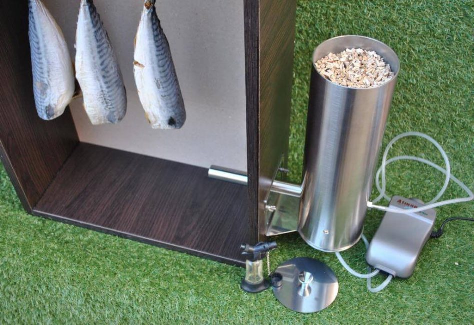 Fumoir avec générateur de fumée. Une trémie avec des copeaux de bois et un ventilateur sont visibles