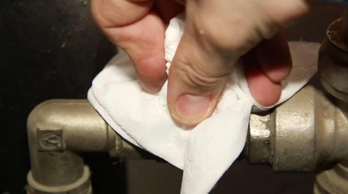 Le robinet est essuyé avec une serviette en papier