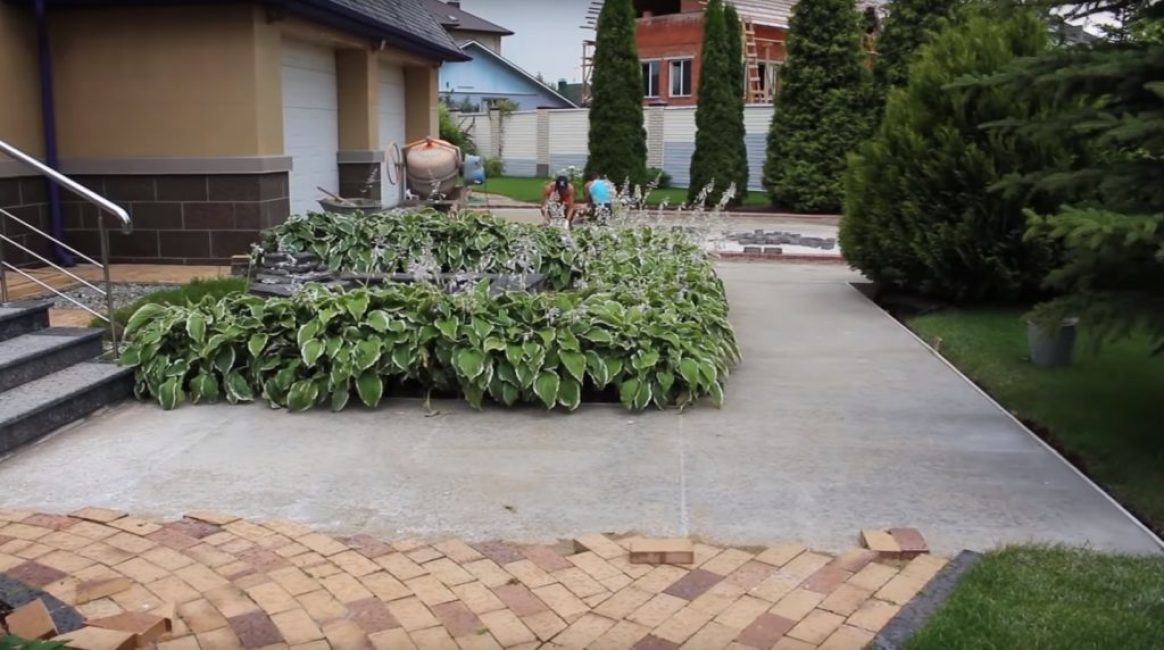 La zone préparée pour la pose des tuiles est clôturée, recouverte d'une sculpture et nivelée avec un pilon