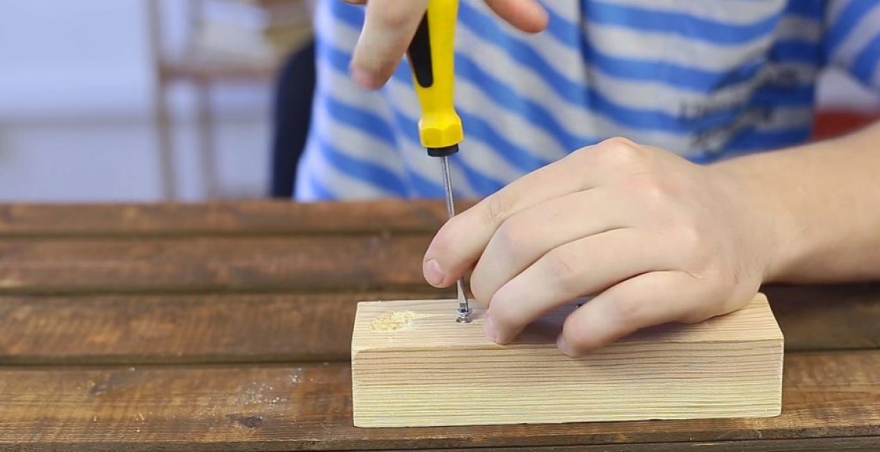 Une fois la fente mise à jour, la vis peut être dévissée sans problème avec un tournevis cruciforme ordinaire