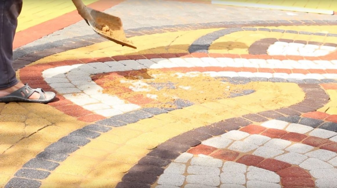 Le sable est versé en petite couche sur les carreaux posés