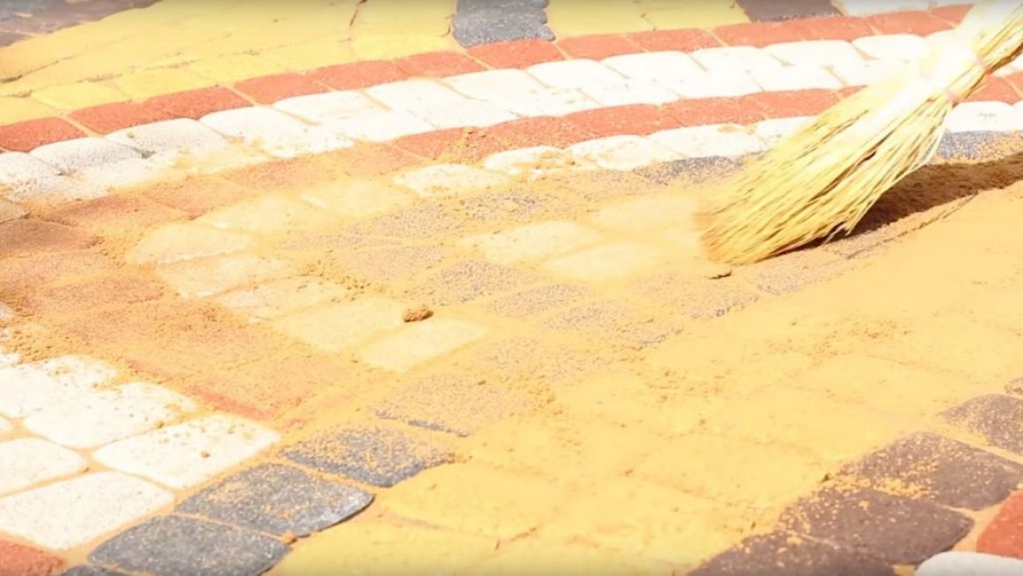 Ensuite, le sable est réparti uniformément sur la surface à l'aide d'un balai conventionnel.