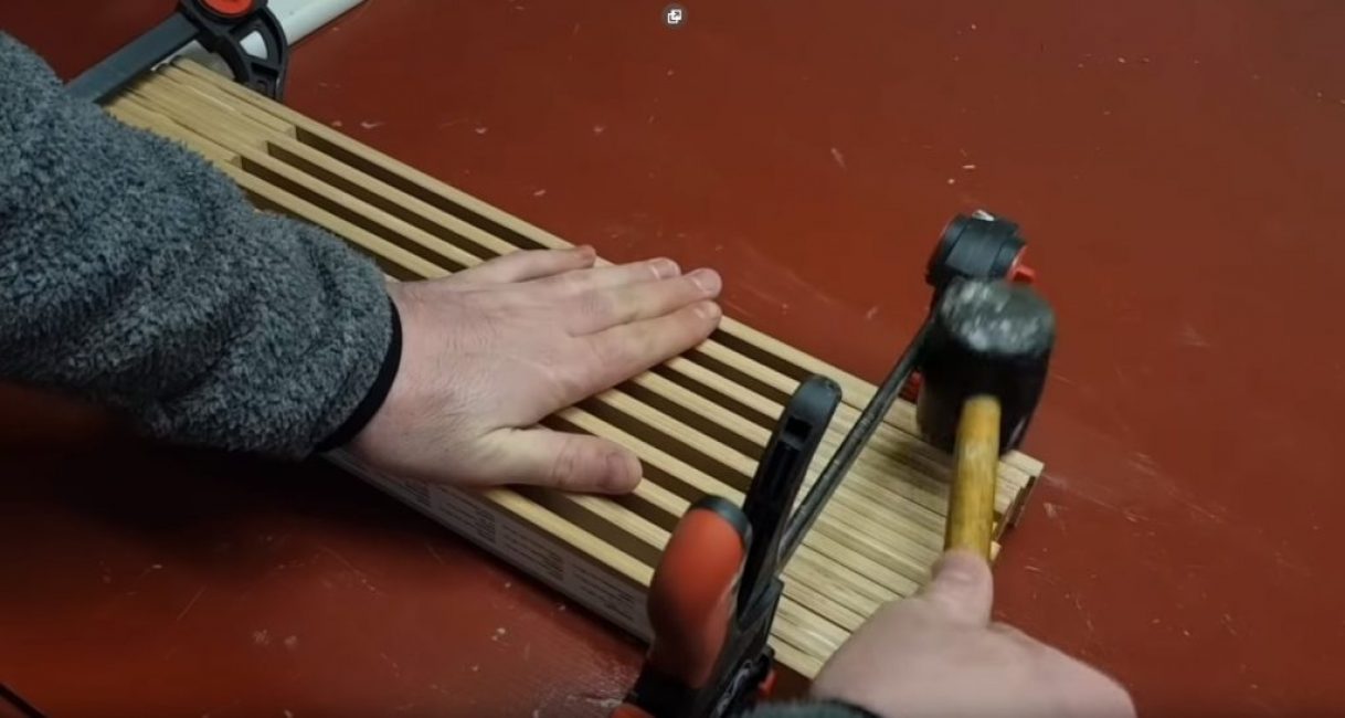 Mise à niveau des planches à partir desquelles le stand est assemblé avec un maillet
