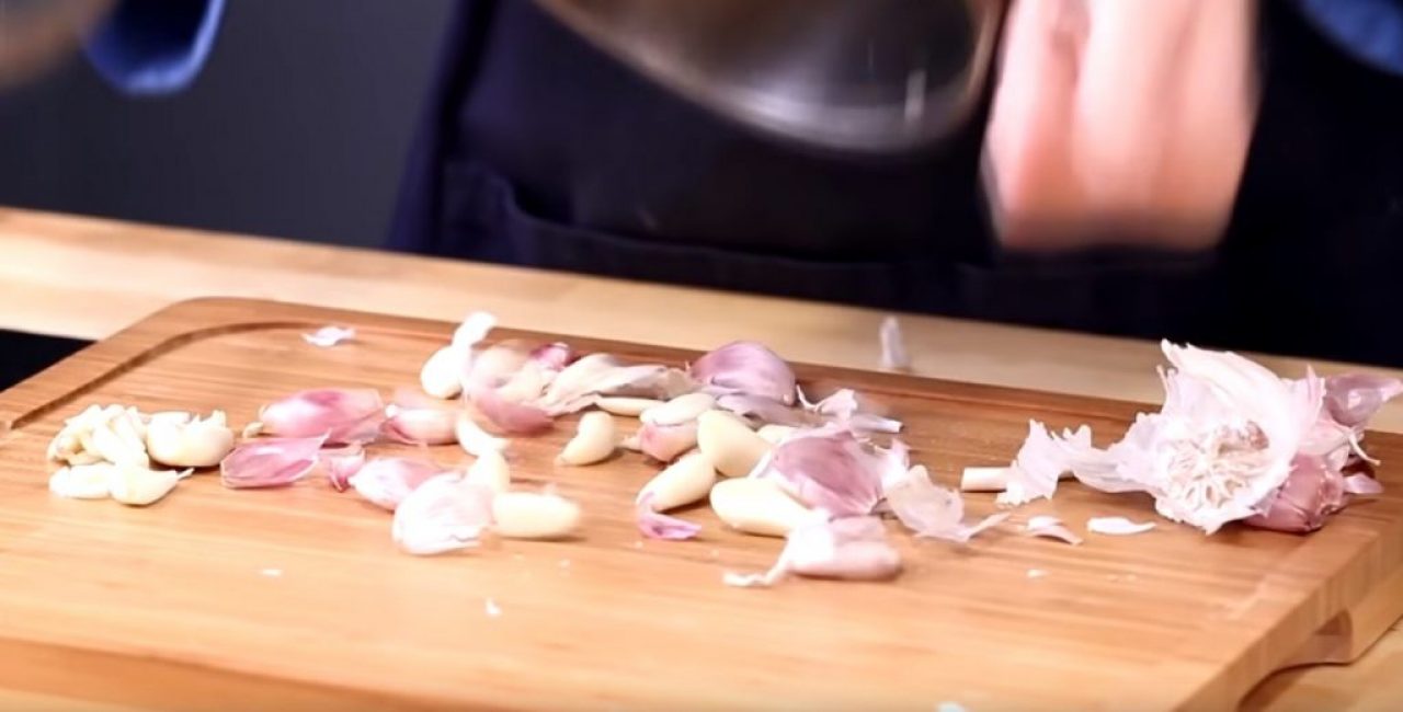 L'ail pelé est versé sur une planche à découper