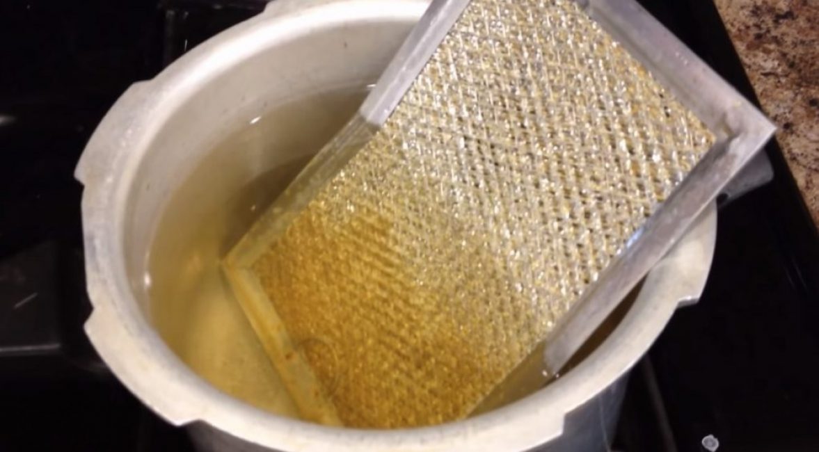 Grille préparée pour la re-ébullition. La partie contaminée est immergée dans le liquide, la partie nettoyée est hors du liquide.