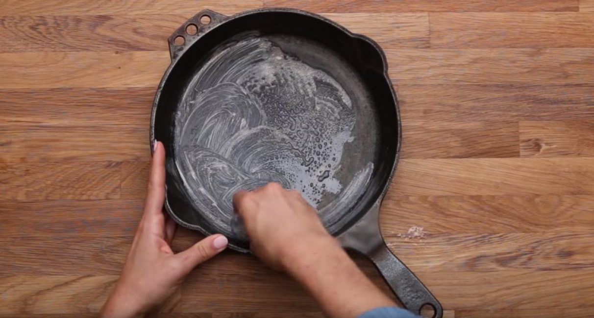 Le liquide vaisselle est appliqué uniformément sur la surface de la casserole.