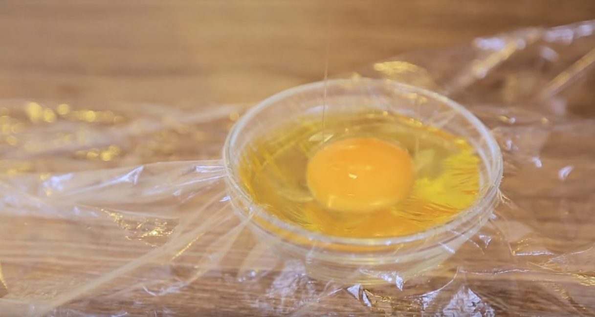 L'œuf est cassé et placé dans un bol sur le film