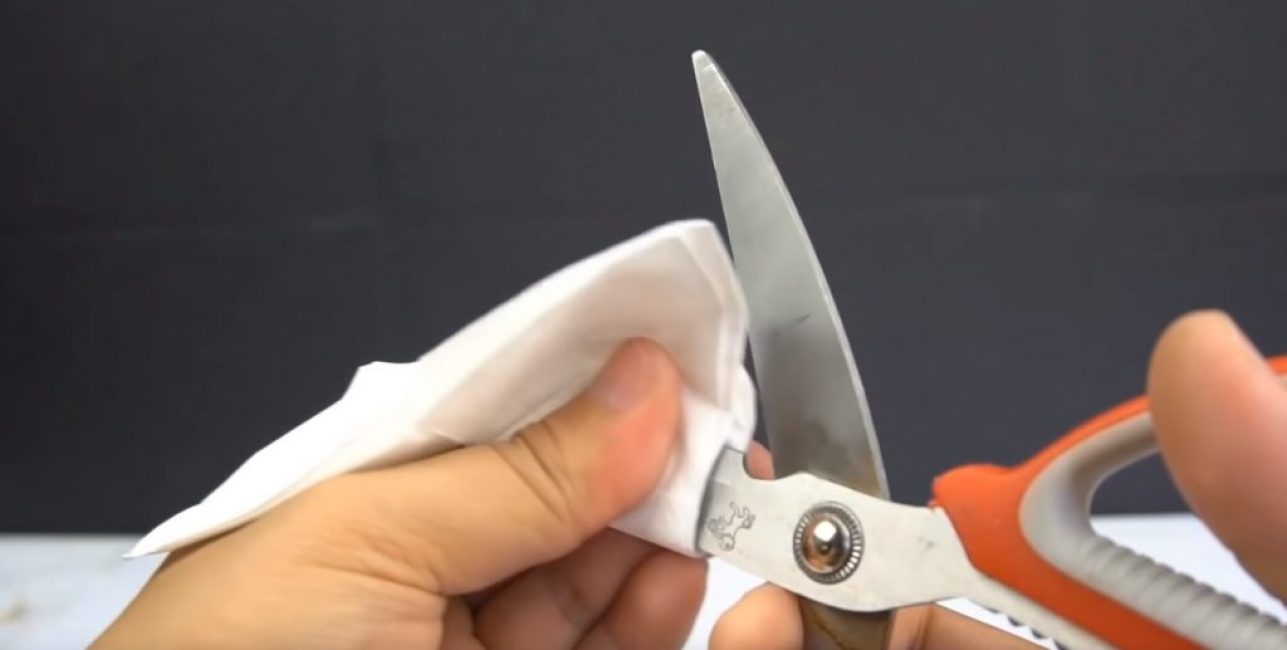 Après l'affûtage, les ciseaux sont essuyés avec une serviette.