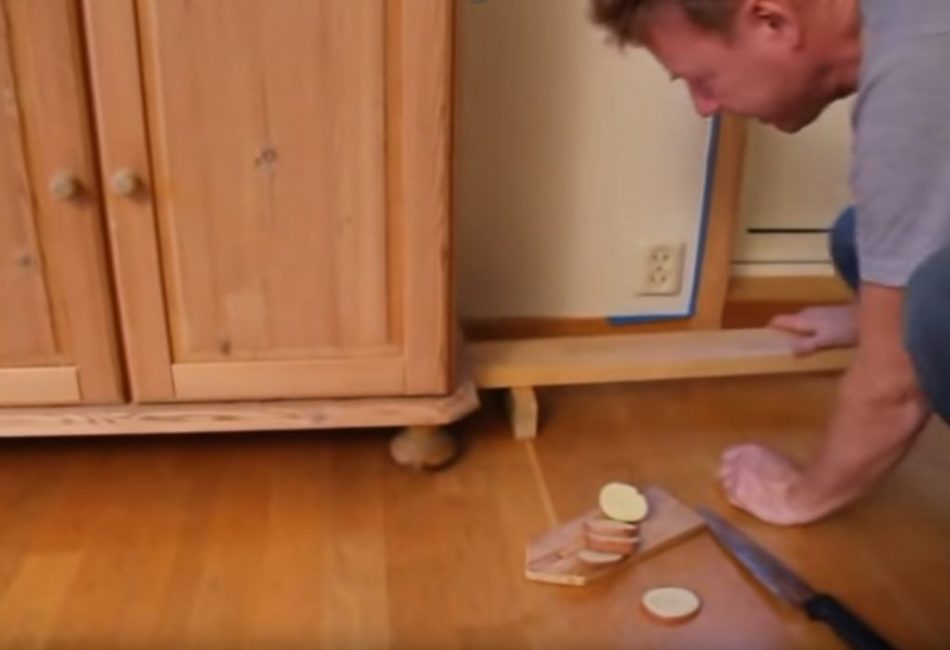 Ensuite, une longue planche est glissée sous l'armoire, qui est placée sur la butée.