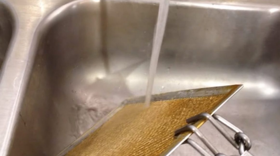 Ensuite, le robinet est ouvert et un jet d'eau est dirigé vers la partie prétraitée de la grille.