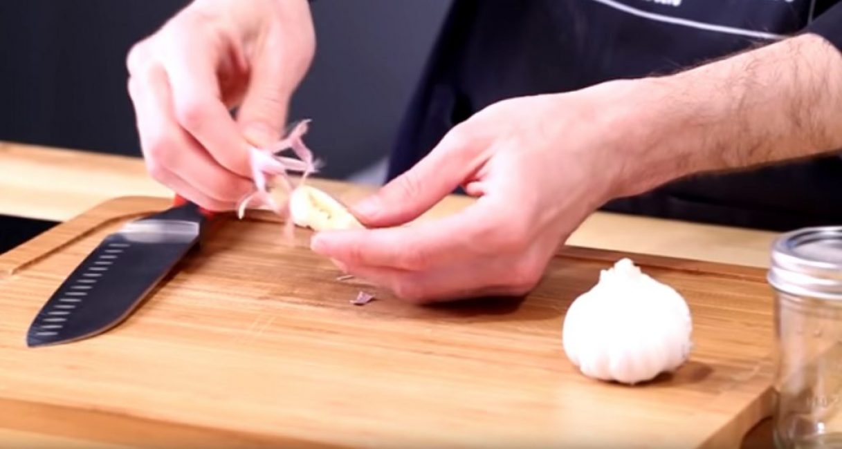 Retirer l'enveloppe extérieure d'une gousse d'ail après l'avoir pressée