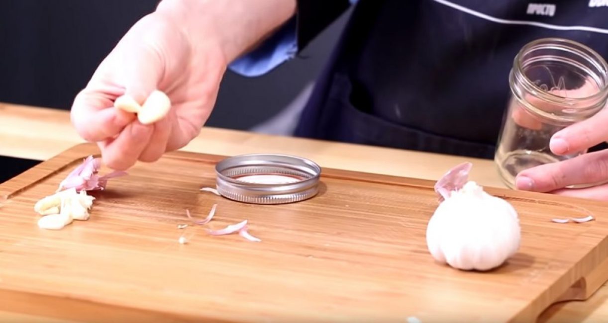 Le pot est ouvert et une gousse d'ail pelée en est retirée.