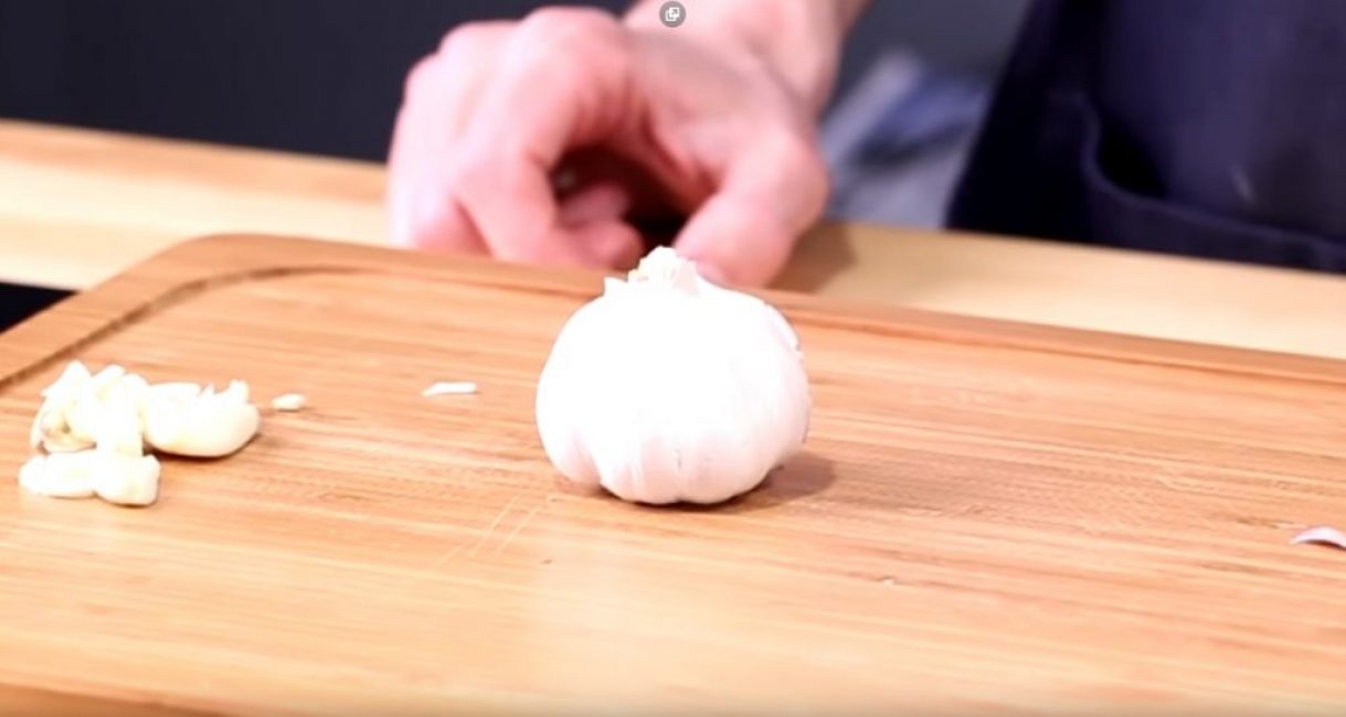 La tête d'ail est placée sur une planche à découper