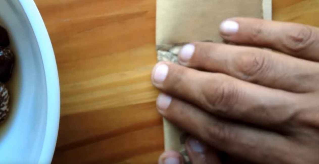 Dans un mouvement circulaire, vous devez frotter les graines à l'intérieur du papier de verre