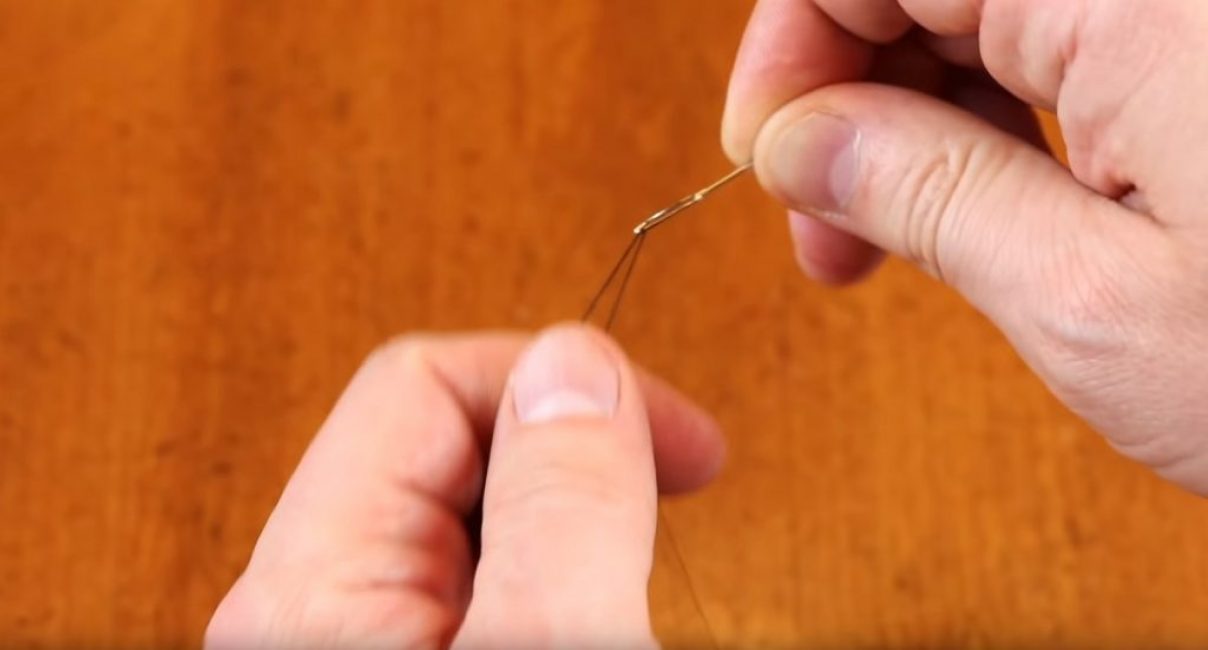 Fil enfilé dans le chas d'une aiguille