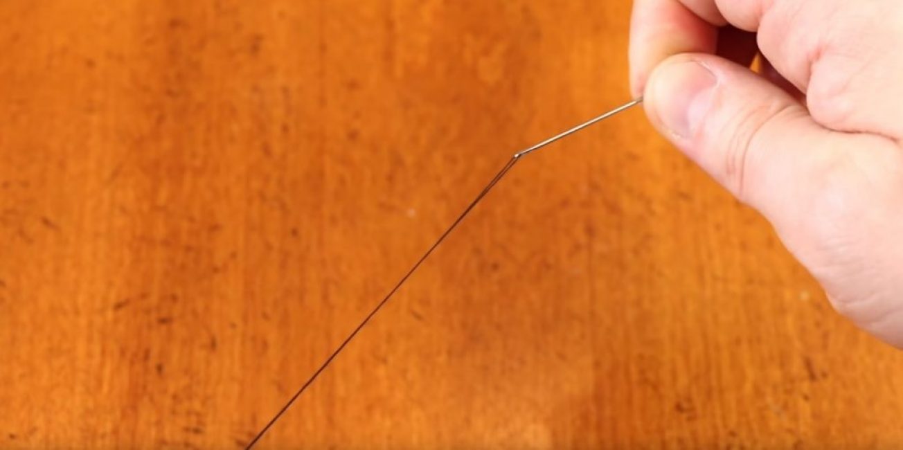 Fil enfilé dans une aiguille avec un petit chas