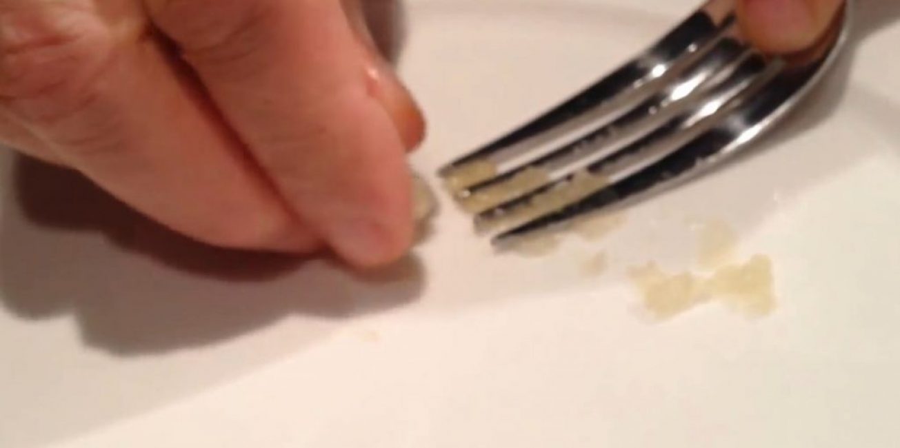 Une gousse d'ail est placée sur le bout d'une fourchette