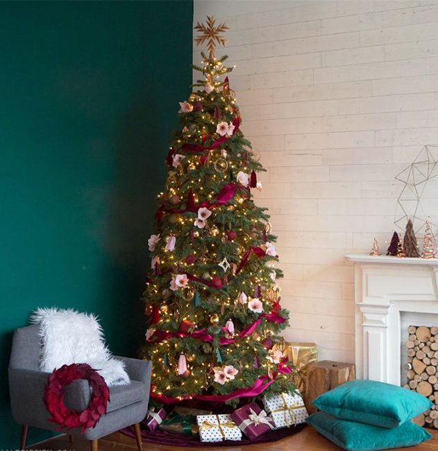 Le ruban de framboise et les délicats pétales de fleurs roses se marient bien avec la verdure des aiguilles.