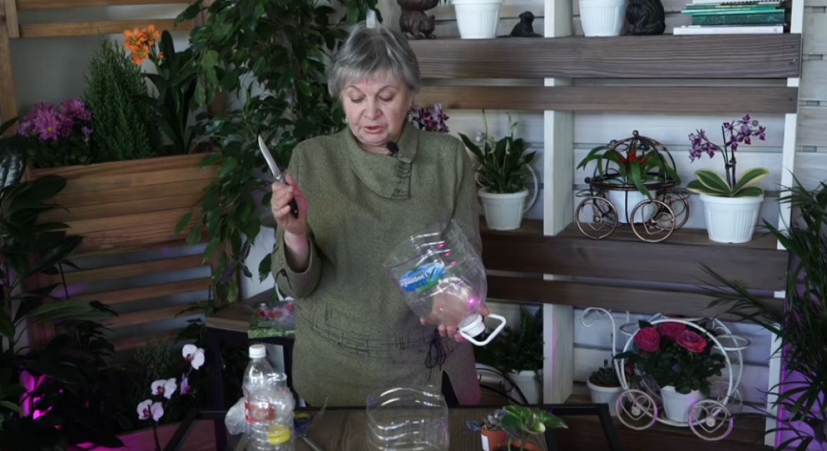 Nous prenons une grande bouteille en plastique de cinq litres d'eau et la coupons en deux parties.