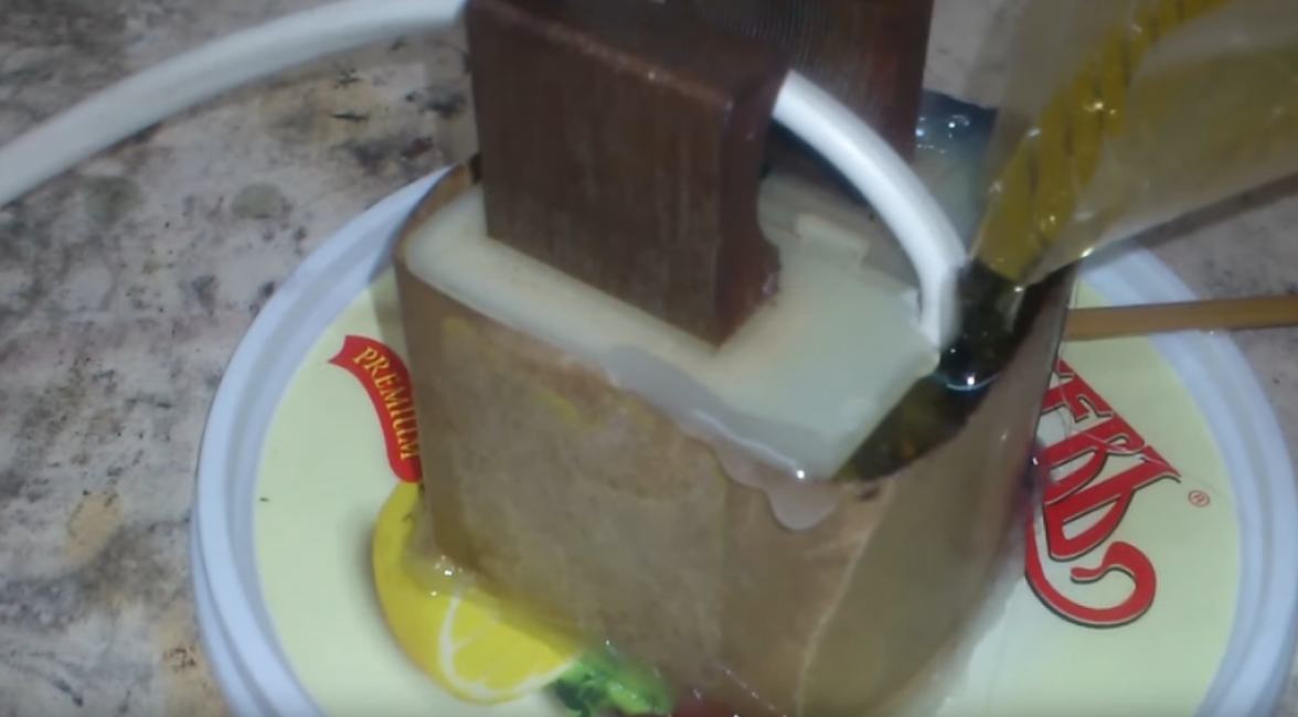 Avant de couler la résine, collez les boîtes de peinture avec un pistolet à colle afin que l'époxy ne coule pas. Ensuite, en un mince filet, commencez à verser la résine.