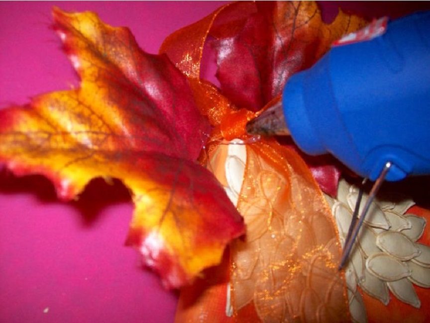 Un ruban d'organza et une feuille d'érable décorative sont collés dans le coin du tableau.