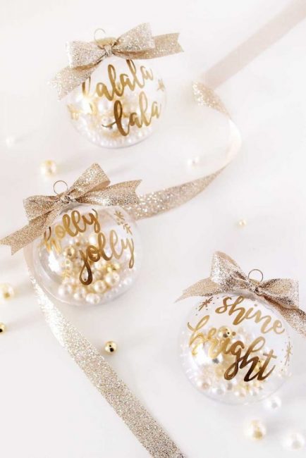 Les boules dorées gracieuses avec des perles sont une décoration chic. Il suffit de mettre quelques perles de perles artificielles à l'intérieur de la boule, d'écrire des souhaits avec un marqueur doré et d'accrocher cette beauté sur un ruban doré texturé.