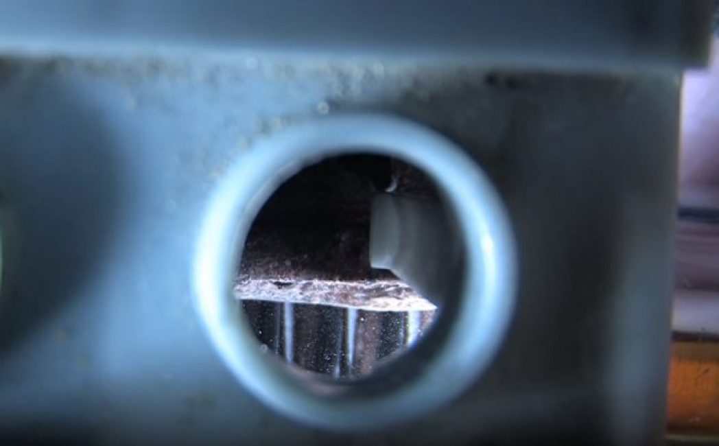 À l'aide d'une lampe de poche, vous pouvez voir la sulfatation à l'intérieur de la batterie - un revêtement blanc sur les plaques.