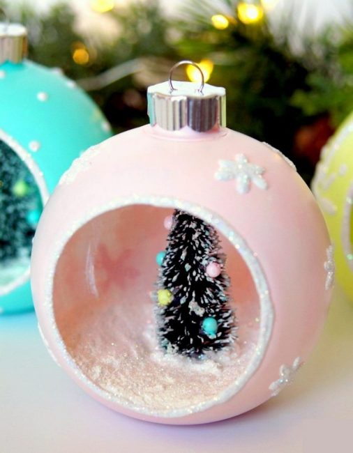 Ballons de style rétro. Ceux-ci peuvent être fabriqués à partir d'un flan en plastique, il vous suffit de découper soigneusement une petite fenêtre, de peindre l'extérieur avec des acryliques pastel et de créer une composition du Nouvel An, en la fixant avec un pistolet à colle. La neige artificielle sera très utile