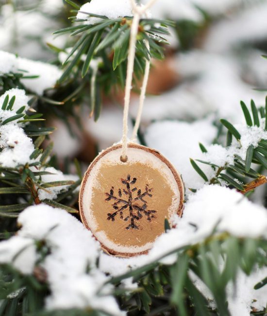 Un flocon de neige sur une coupe à la scie est très mignon. Il est facile à réaliser avec un brûleur à gaz ou simplement à peindre à l'acrylique. Pour obtenir une image en trois dimensions, les bords du flocon de neige sont teintés d'or. La décoration rustique est prête, il ne reste plus qu'à l'accrocher avec de la ficelle sur une branche d'épicéa