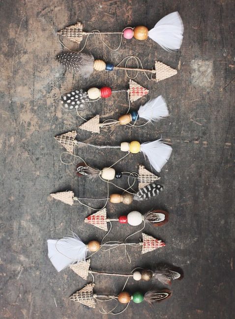 Vous pouvez décorer le sapin de Noël avec des flèches décoratives. Ils sont fabriqués à partir de branches, de carton, de perles, de paillettes et de plumes.