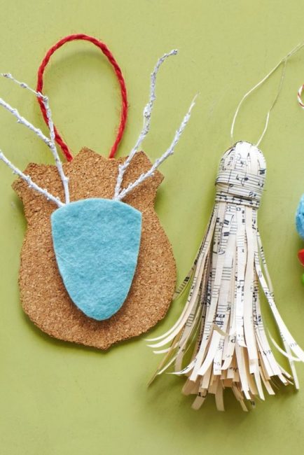 Le pendentif en papier à notes est une décoration de Noël originale. Pour le fabriquer, vous aurez besoin d'un bouchon de liège comme base, de papier à musique coupé en fines lanières, d'un ruban ou d'un fil solide. Le liège est enveloppé de papier, les bords sont pliés avec des ciseaux, fixés avec de la colle pour plus de solidité.