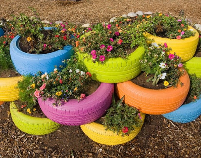 Un parterre de fleurs composé de plusieurs pneus