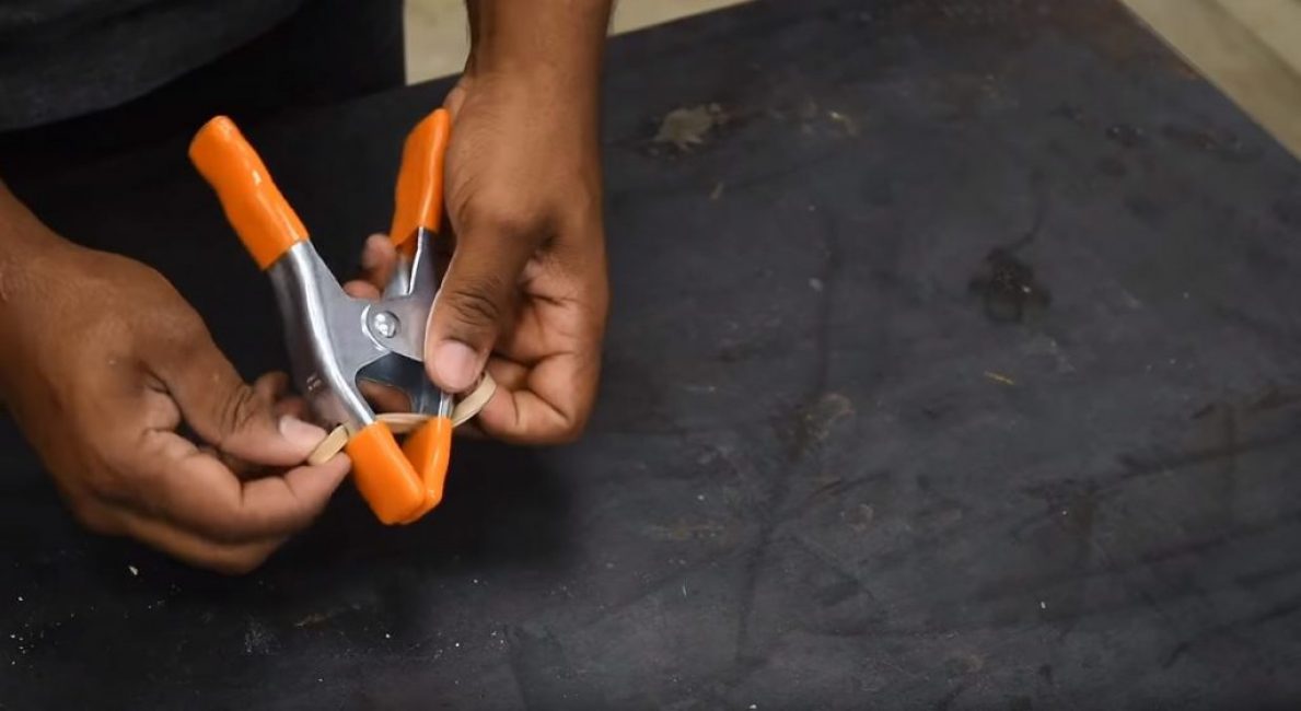 Nous forons deux trous dans le bas de la pince et tirons un anneau en caoutchouc à travers eux.