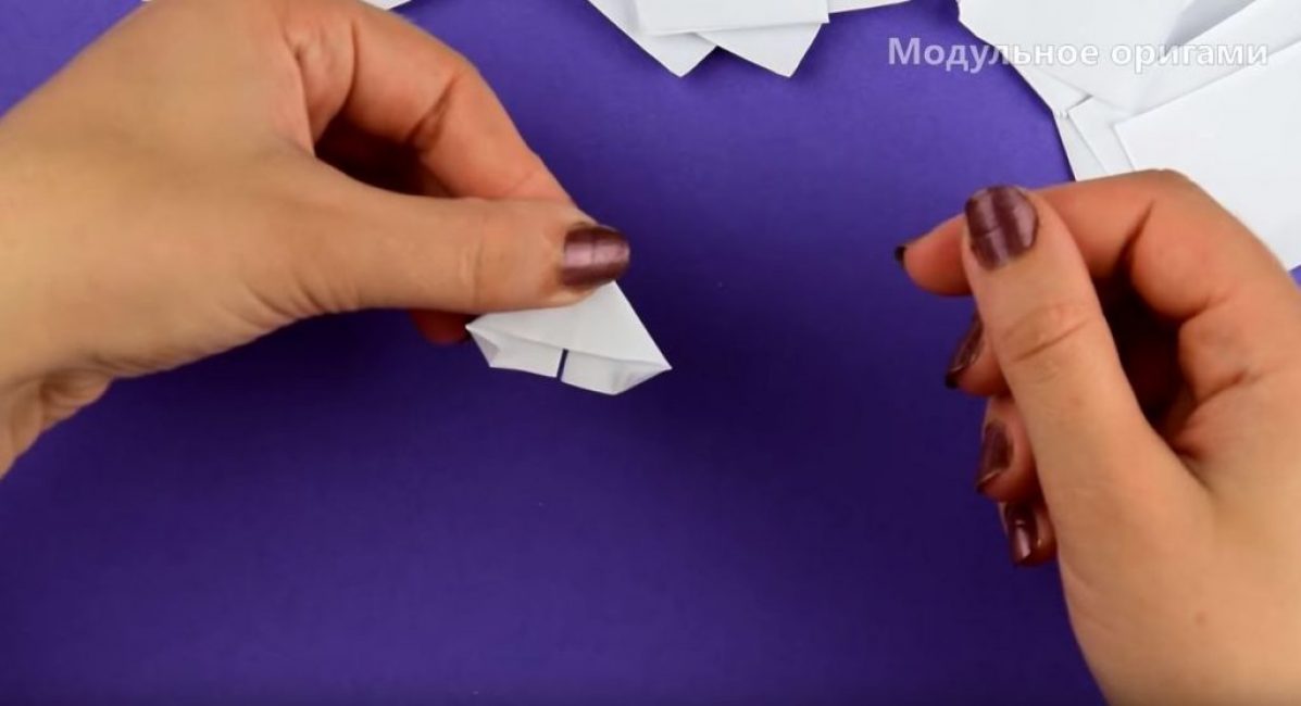 Retournez la pièce de l'autre côté et pliez les coins extérieurs vers l'intérieur