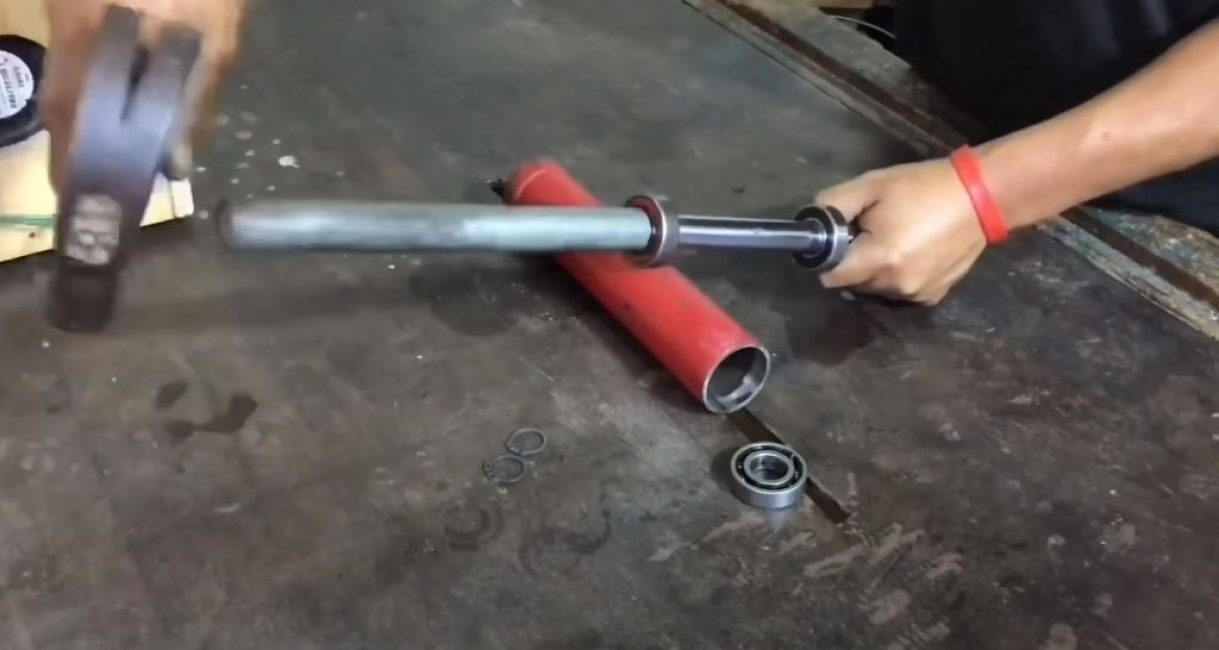 On pose des roulements sur la tige de l'amortisseur