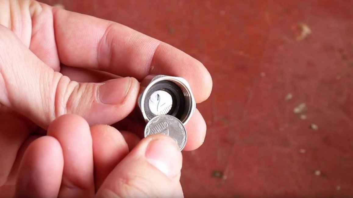 Nous mettons une pièce de monnaie d'une taille appropriée dans l'écrou