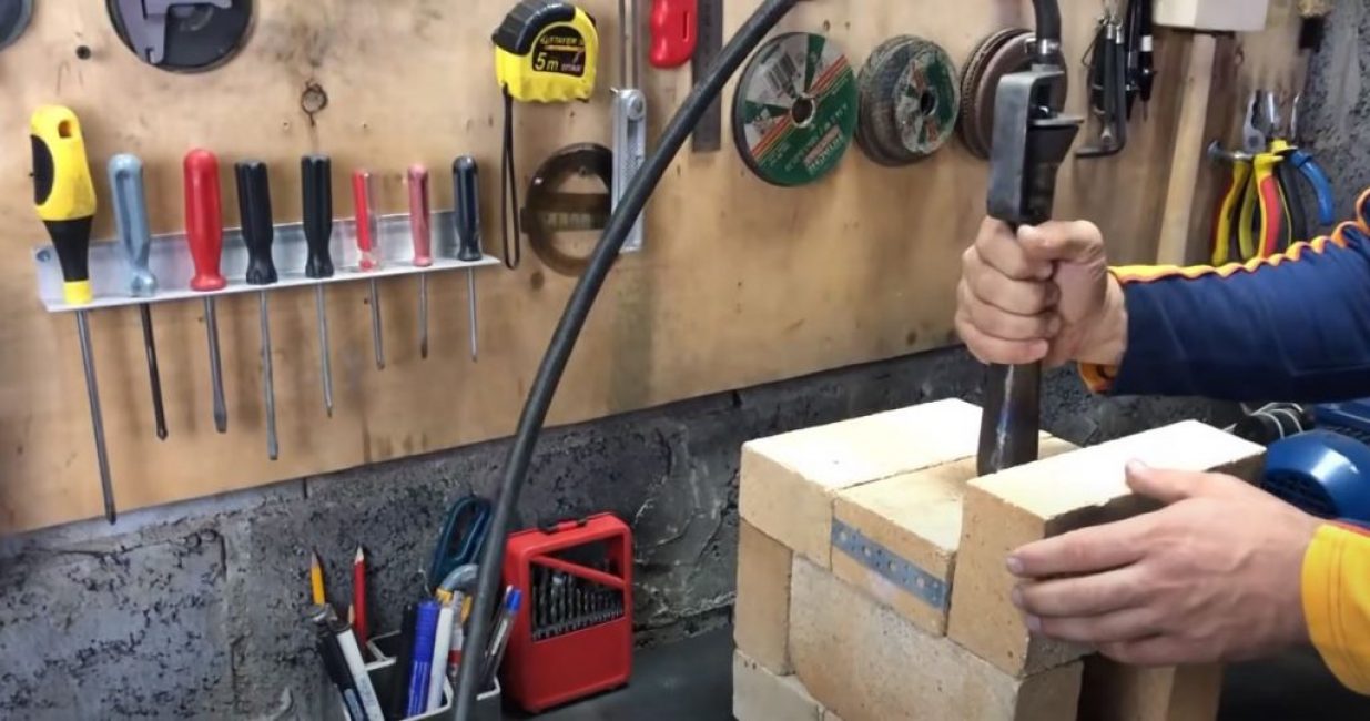 Nous connectons le brûleur à gaz au cylindre et l'insérons dans le foyer