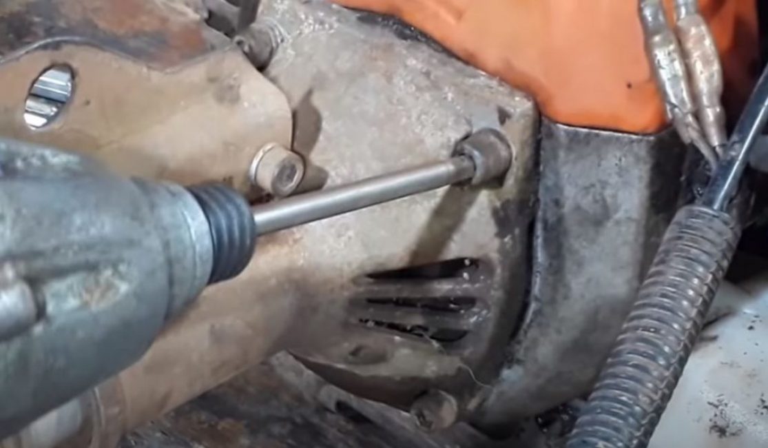 Nous retirons la tige avec l'arbre de la tondeuse à gazon