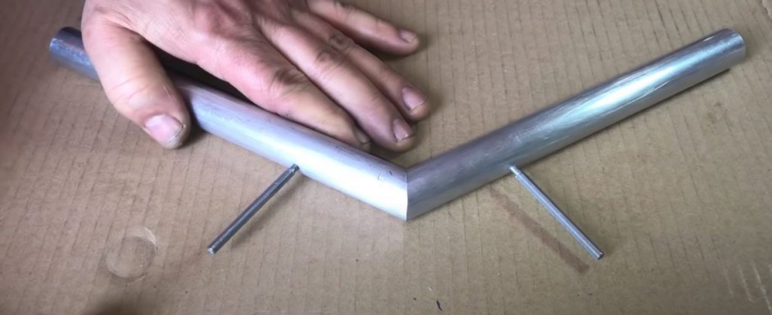 Nous posons les tuyaux sur le coin, combinons les trous et martelons les goupilles