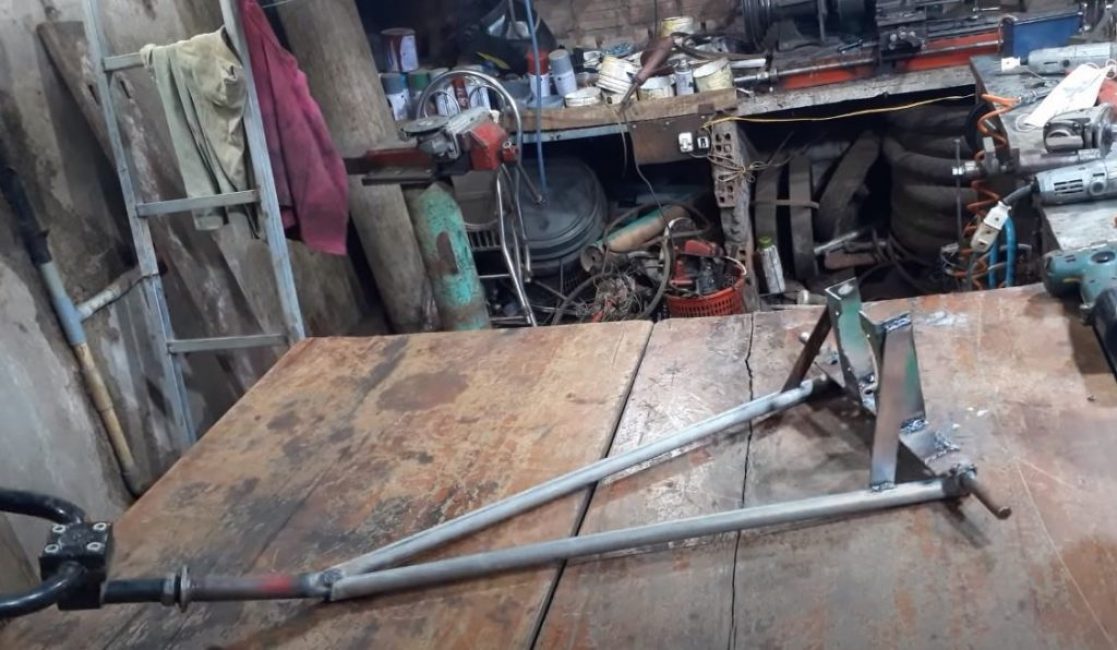 Nous soudons le cadre de la trancheuse à partir des coins, des tuyaux métalliques, du bois rond et d'un guidon de vélo